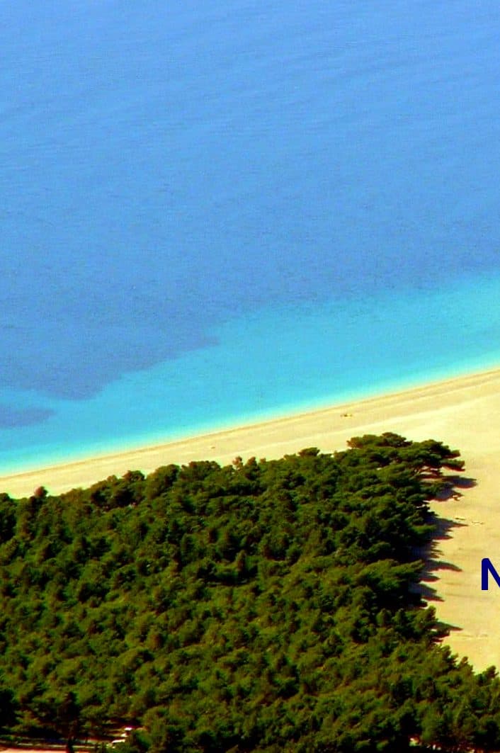 Aerial view of a palm-fringed sandspit and turquoise lagoon