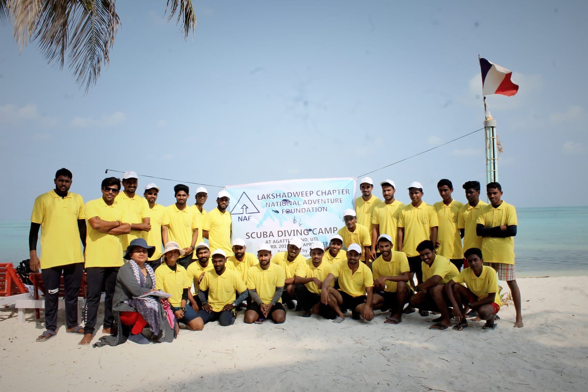 A scuba diving camp cohort assembled beneath the Chapter banner