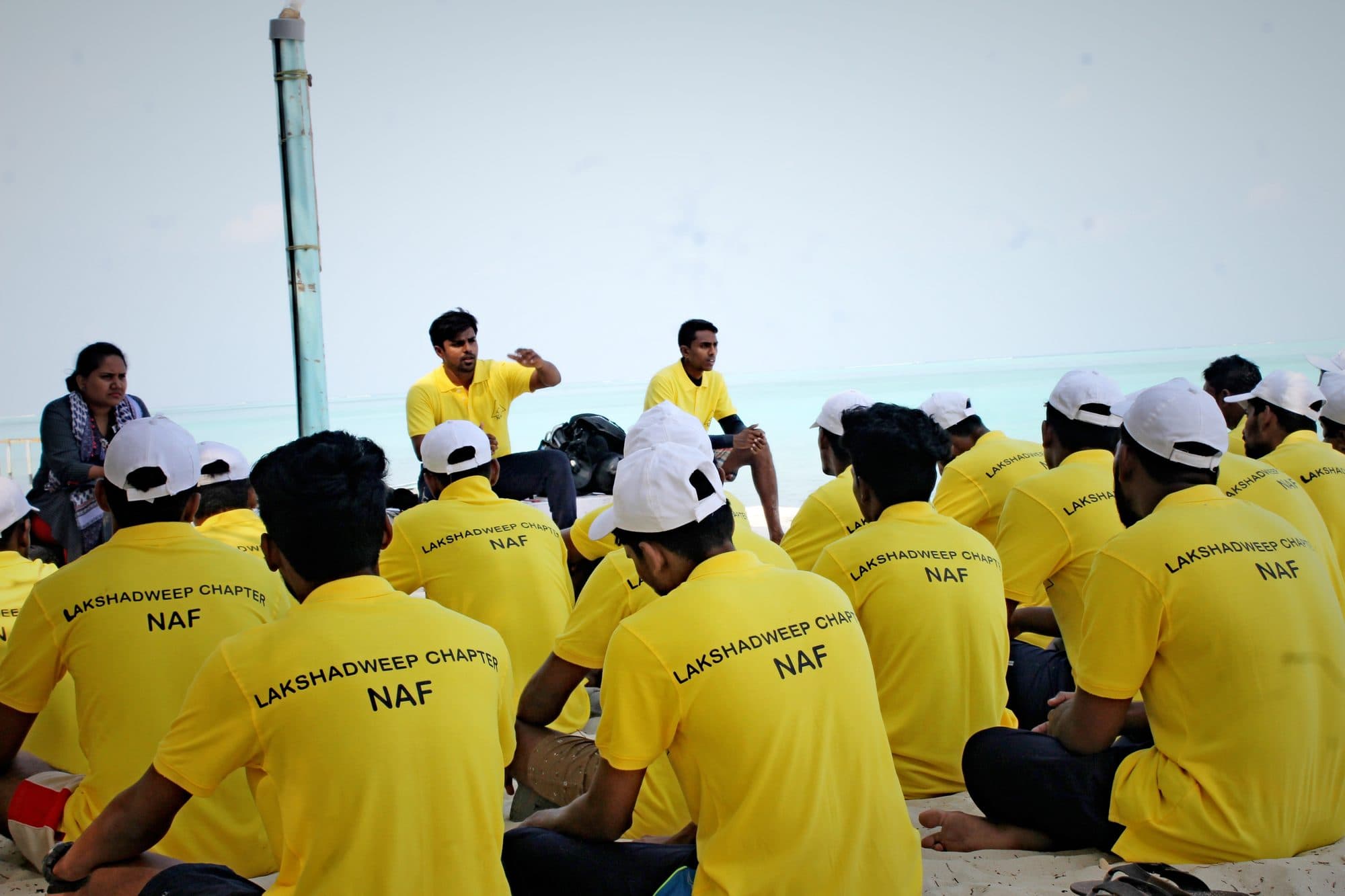 Students seated on the beach during a shore briefing