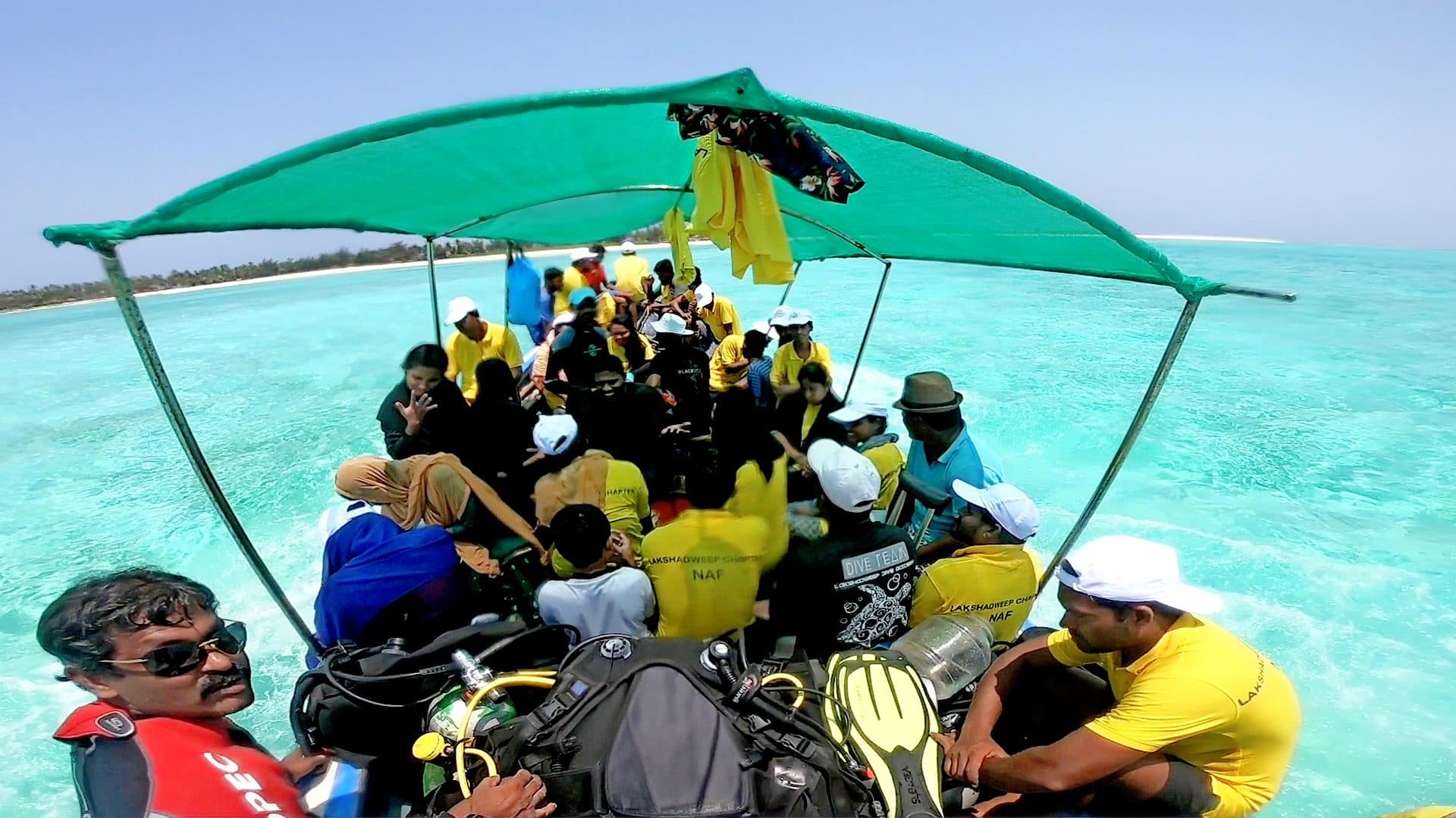 Divers and equipment aboard the dive boat heading out across the lagoon