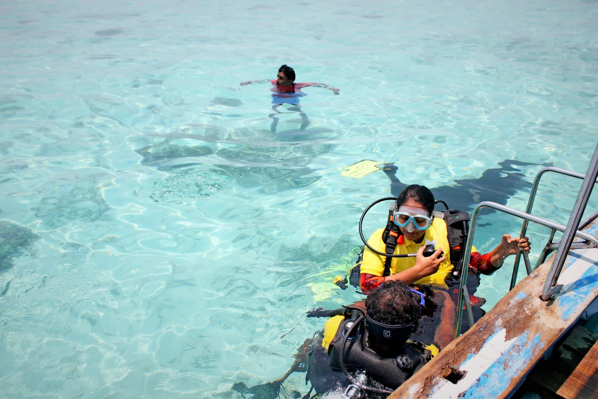 A student entering the water from the dive boat ladder